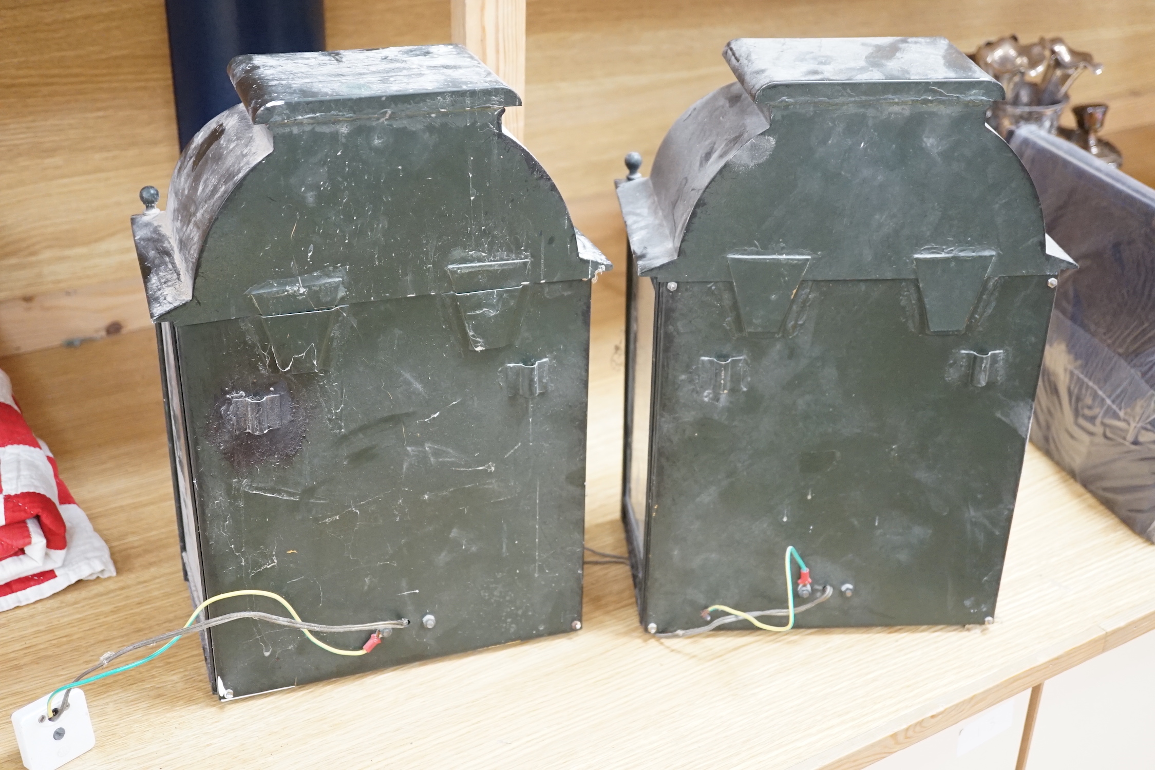 A pair of 19th century black painted tin wall lanterns with three glazed sides. 37cm tall